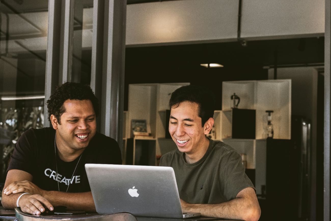 Dos socios revisando su operación en una laptop